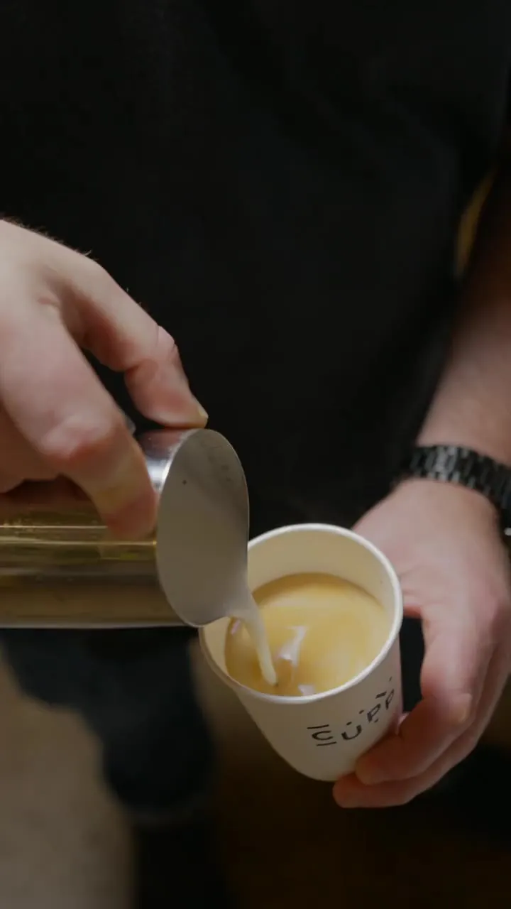 Latte art being poured into a CUPP cup