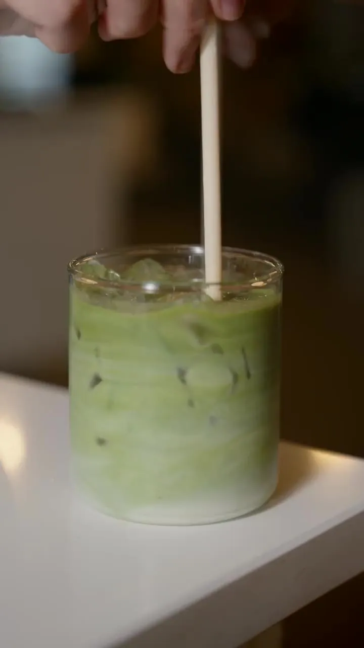 Iced matcha latte being stirred